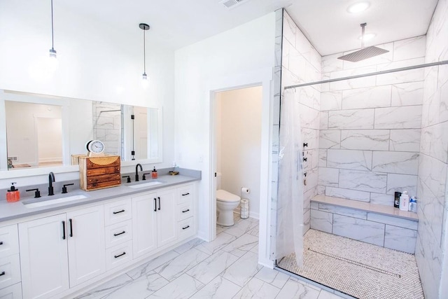 bathroom featuring tiled shower, toilet, tile patterned flooring, and dual bowl vanity