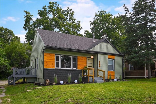 view of front facade with a deck and a front lawn