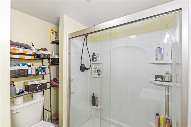 bathroom featuring toilet and an enclosed shower