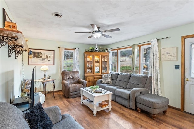 living room with hardwood / wood-style flooring, ceiling fan, and a healthy amount of sunlight