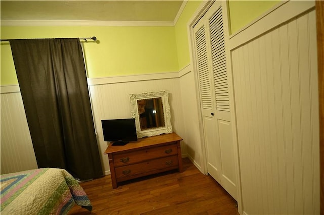 bedroom featuring a closet, dark hardwood / wood-style floors, and ornamental molding