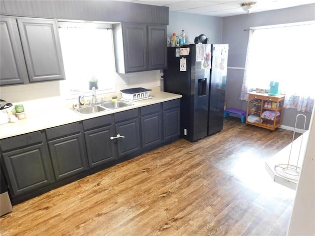 kitchen with stainless steel fridge with ice dispenser, sink, hardwood / wood-style floors, and a wealth of natural light