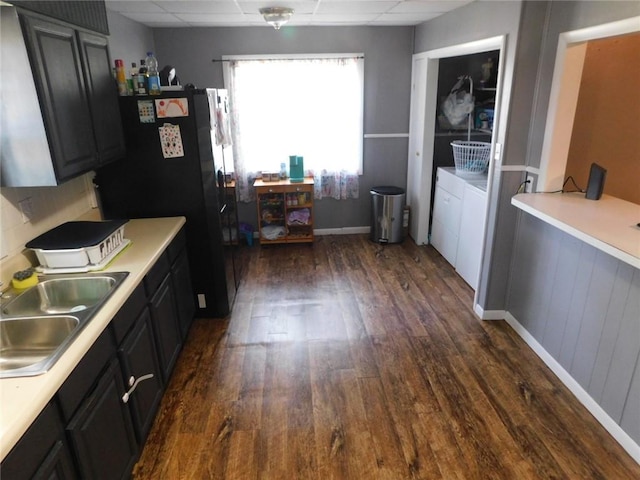 kitchen with washer and clothes dryer, sink, dark wood-type flooring, and a paneled ceiling