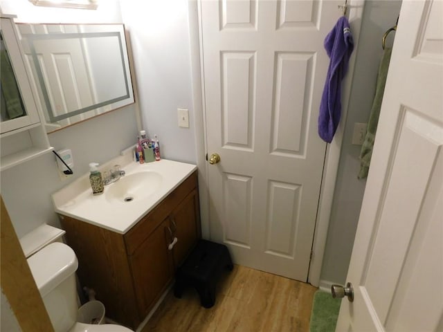 bathroom featuring vanity, hardwood / wood-style floors, and toilet