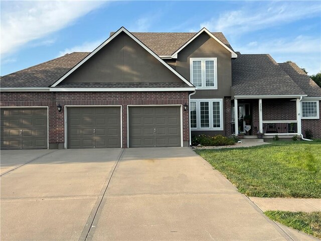 view of front facade with a front yard, a garage, and covered porch