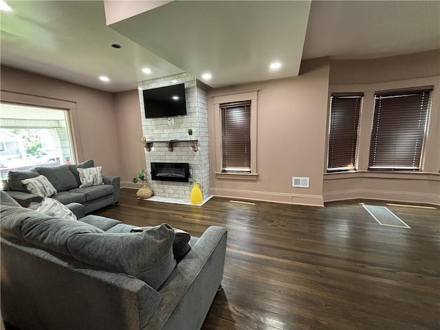 living area with recessed lighting, baseboards, wood finished floors, and a fireplace