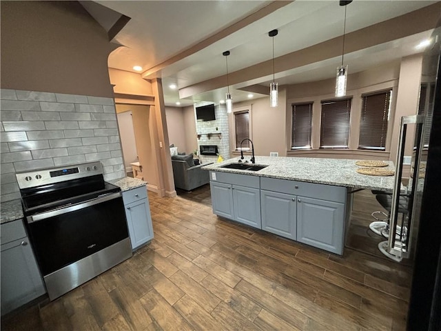 kitchen with gray cabinetry, stainless steel electric range, tasteful backsplash, and a sink