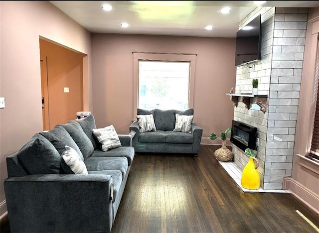 living room featuring dark wood-style floors, recessed lighting, a fireplace, and baseboards