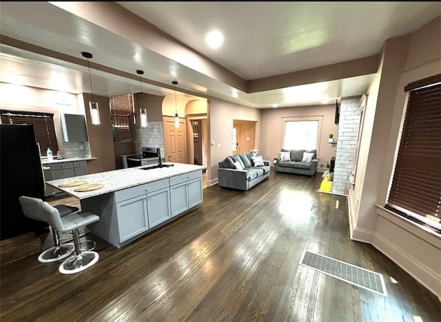 kitchen featuring tasteful backsplash, visible vents, dark wood finished floors, open floor plan, and gray cabinets