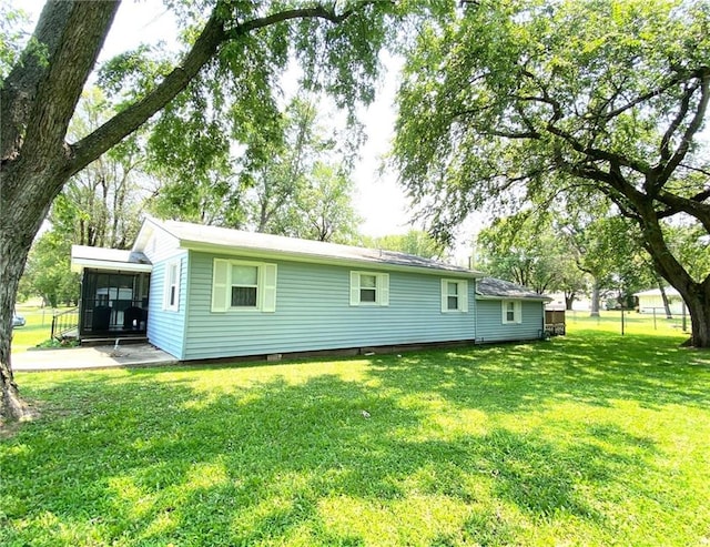 rear view of house featuring a yard and a sunroom