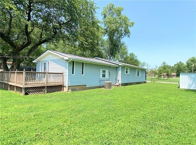 rear view of house featuring a deck, a yard, and cooling unit