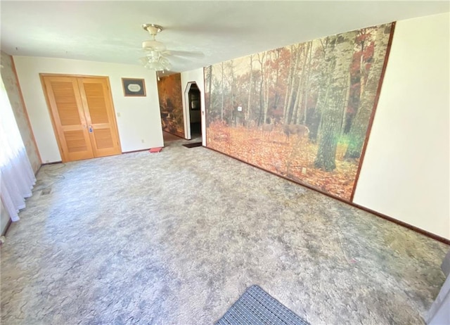 unfurnished living room featuring baseboards, ceiling fan, and carpet floors