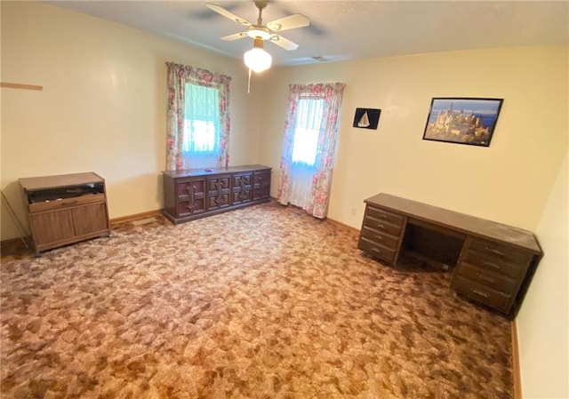 interior space featuring baseboards, a ceiling fan, and carpet