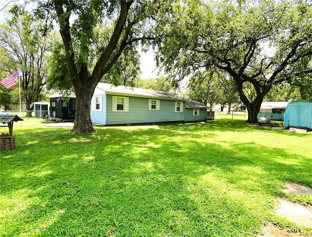 view of yard with a storage shed, fence, and an outdoor structure