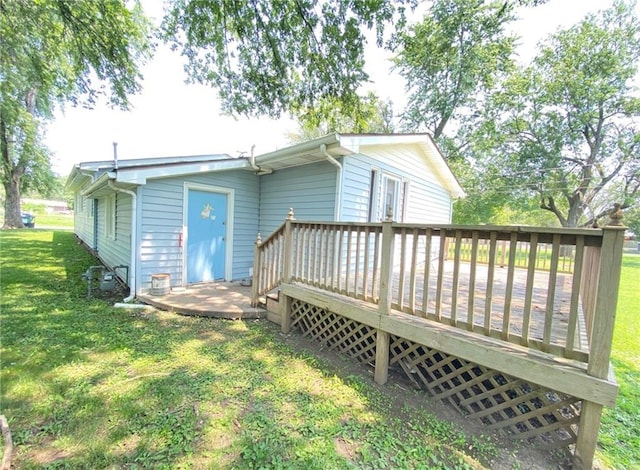 rear view of house with a lawn and a deck