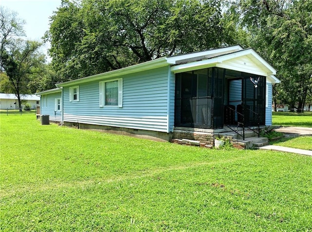 view of front of home featuring entry steps, a front lawn, and cooling unit