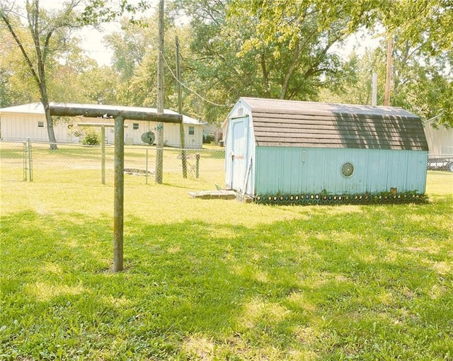 view of yard featuring an outdoor structure, a storage unit, and fence