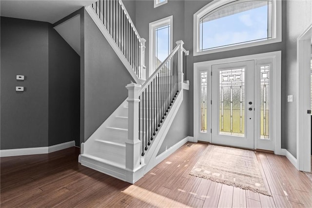 entrance foyer featuring hardwood / wood-style flooring and a towering ceiling