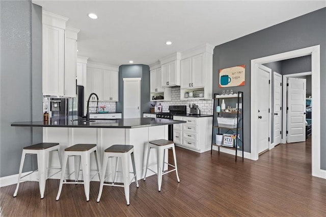 kitchen with dark hardwood / wood-style floors, backsplash, sink, and a kitchen bar