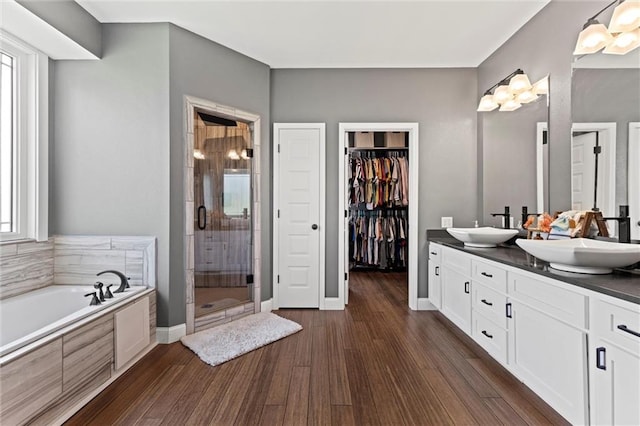 bathroom featuring plus walk in shower, wood-type flooring, and double vanity