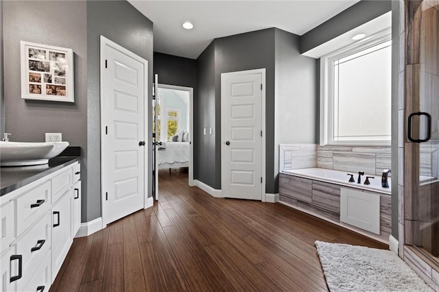 bathroom with separate shower and tub, wood-type flooring, and vanity