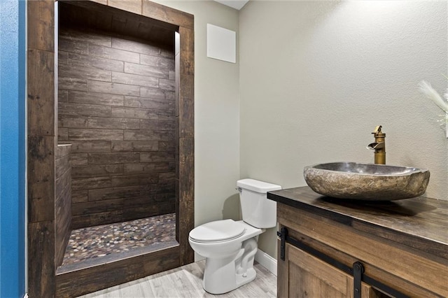 bathroom featuring vanity, toilet, hardwood / wood-style floors, and a shower