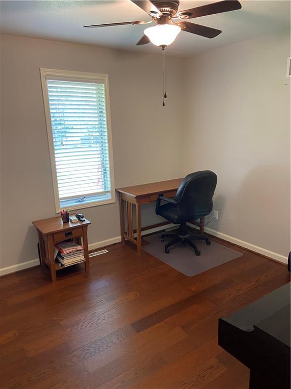 home office featuring dark wood finished floors, baseboards, and ceiling fan