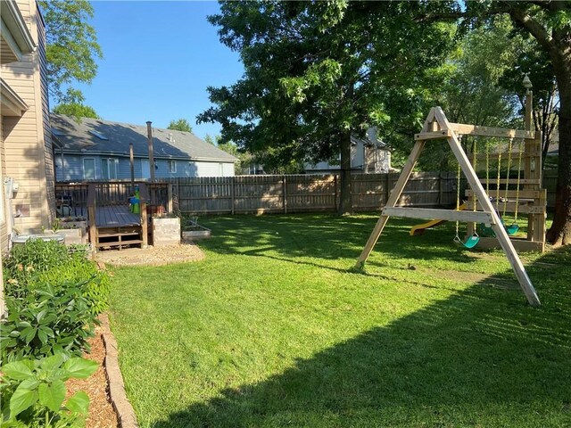 view of yard with a fenced backyard, a playground, and a wooden deck