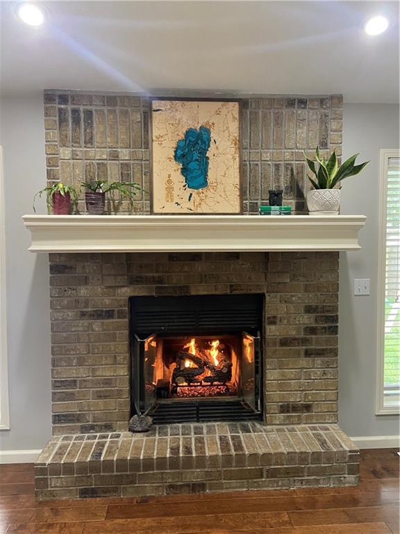 room details featuring a fireplace, baseboards, wood finished floors, and recessed lighting