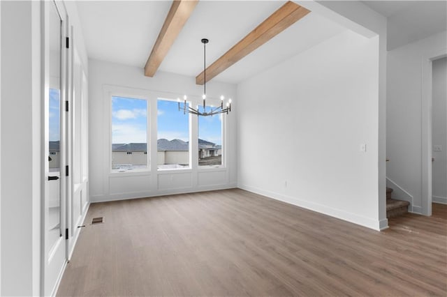 unfurnished dining area with hardwood / wood-style floors, beam ceiling, and a notable chandelier