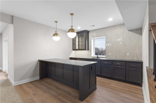 kitchen featuring pendant lighting, dark hardwood / wood-style floors, kitchen peninsula, and sink