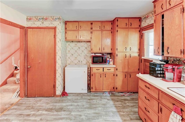 kitchen featuring light hardwood / wood-style floors and fridge