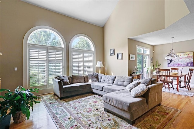 living room with plenty of natural light, high vaulted ceiling, and wood-type flooring