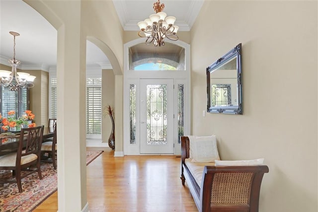 entrance foyer featuring ornamental molding, light hardwood / wood-style floors, and a chandelier