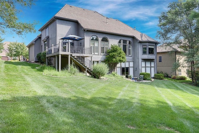 rear view of property featuring a wooden deck and a yard