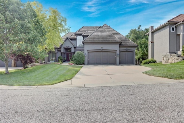 view of front of property with a garage and a front lawn