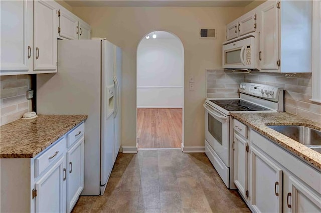 kitchen featuring light wood-type flooring, white appliances, white cabinetry, and tasteful backsplash