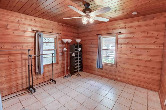 tiled empty room featuring wood ceiling, wood walls, and ceiling fan