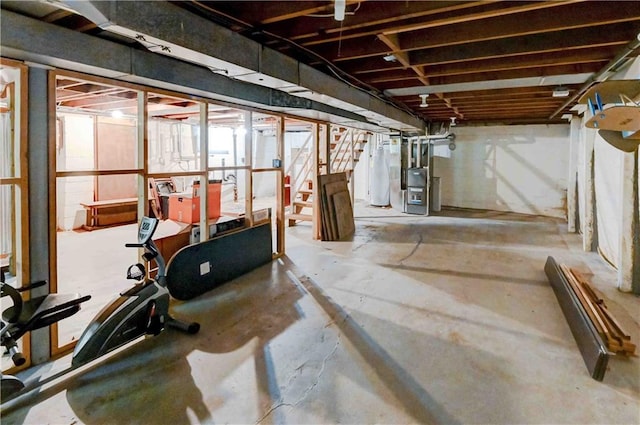 workout room featuring gas water heater and concrete flooring