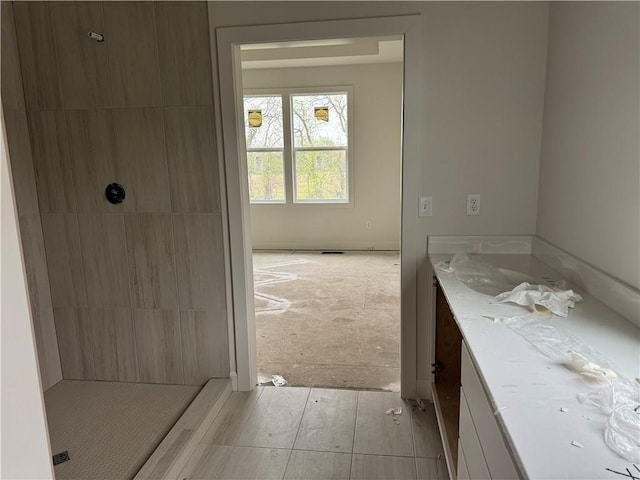 full bathroom featuring vanity and a tile shower