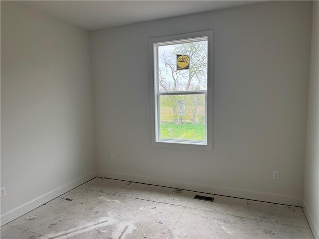 empty room featuring baseboards, visible vents, and a wealth of natural light