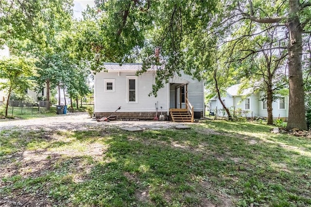 rear view of property featuring a lawn