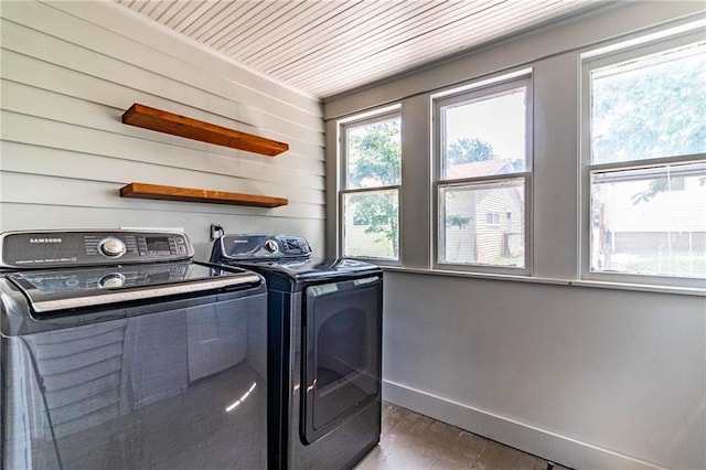 laundry area featuring washing machine and clothes dryer and dark hardwood / wood-style flooring