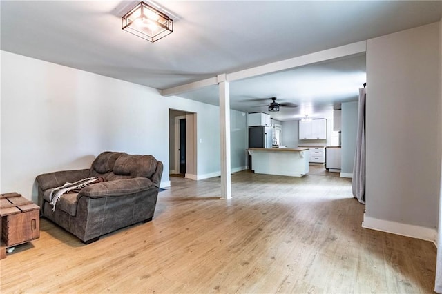 living room featuring light hardwood / wood-style floors and ceiling fan