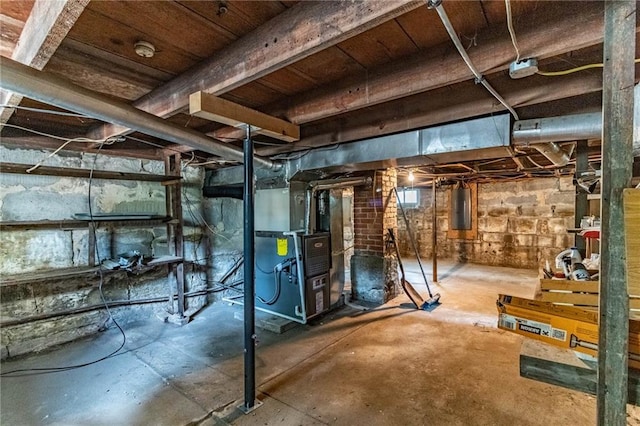 basement with electric panel and heating unit