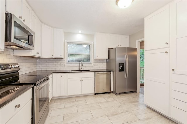 kitchen featuring sink, white cabinets, appliances with stainless steel finishes, and tasteful backsplash