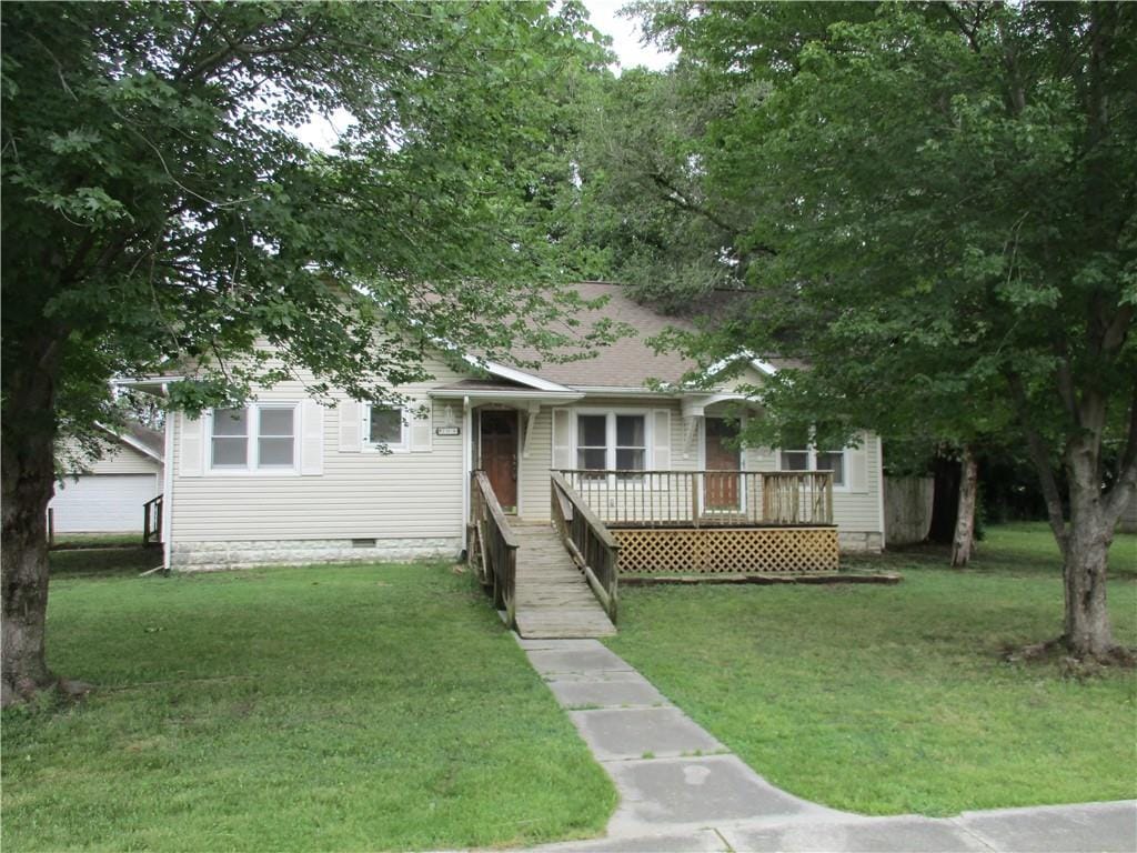 view of front of property with a deck and a front lawn