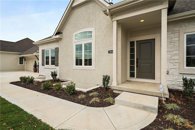 view of exterior entry featuring stone siding, roof with shingles, and stucco siding