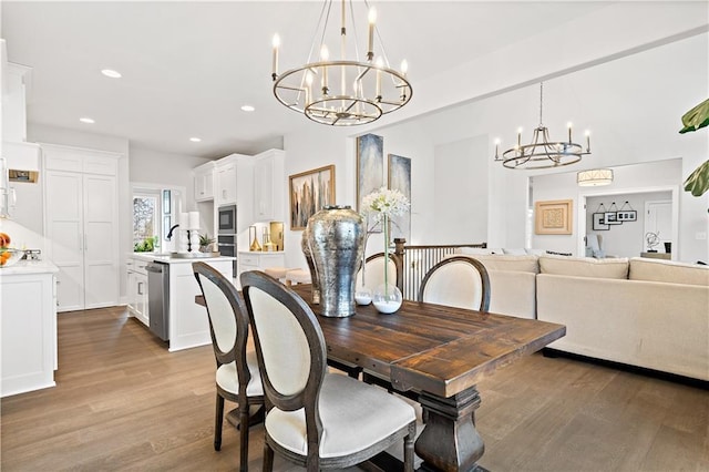 dining room with a chandelier, recessed lighting, and light wood-style flooring