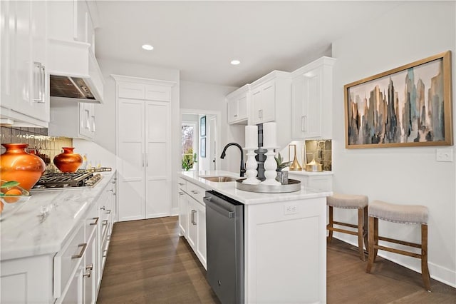 kitchen with decorative backsplash, dark wood-style flooring, stainless steel appliances, white cabinetry, and a sink